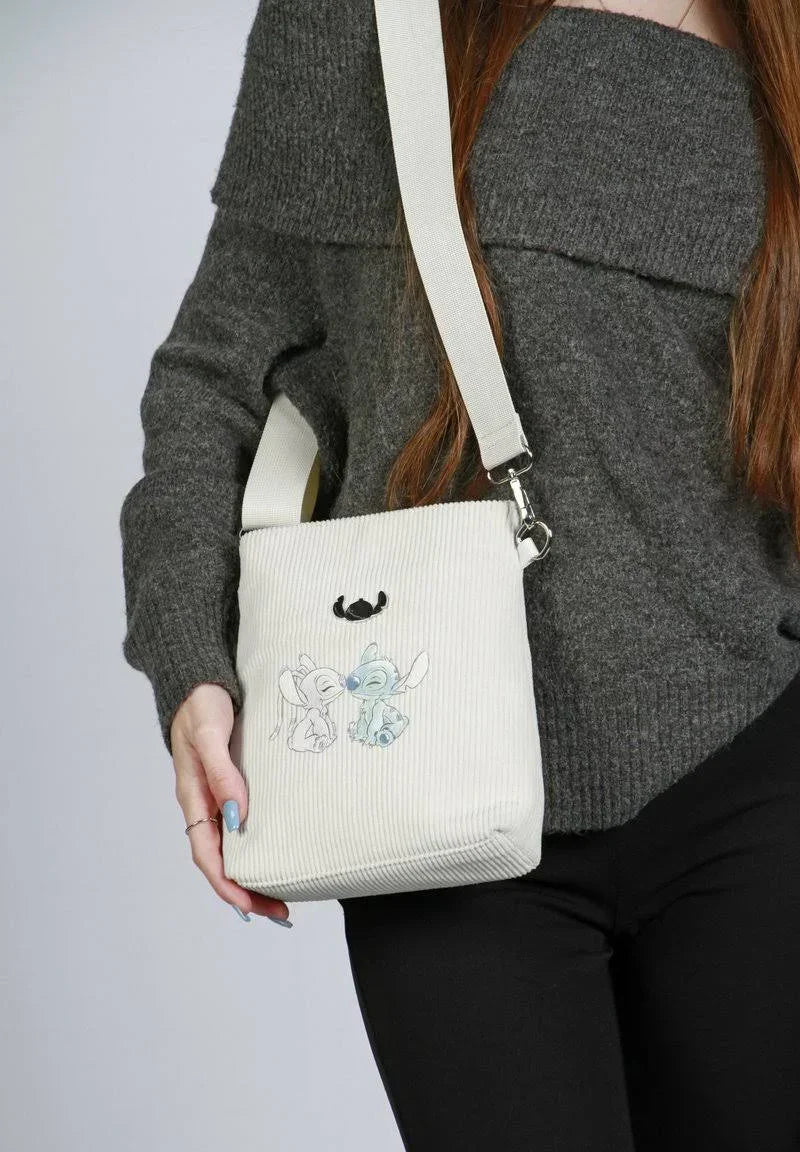 Bolsa infantil tiracolo bege com ilustração de personagens azuis, alça ajustável.